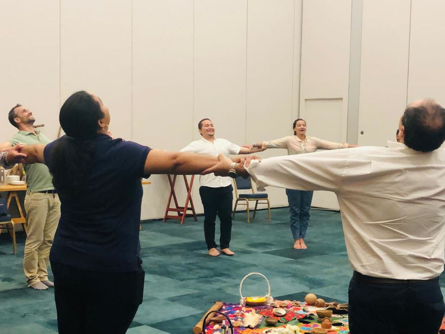 A team standing in a circle with their arms open around an altar laid out on the floor