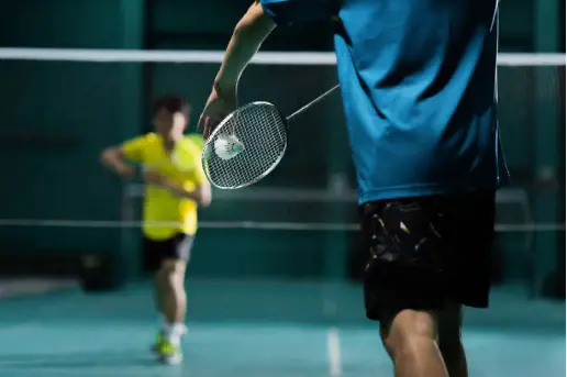 Two players ready to begin a badminton set.