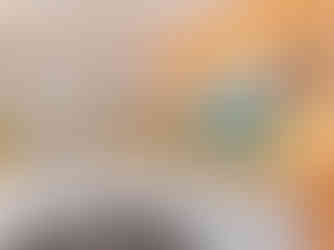 A kitchen with an open pass through into the sunroom. The walls are bright orange and the cabinets are white, some of them are open faced cabinets. There is a vintage spice rack on the wall.