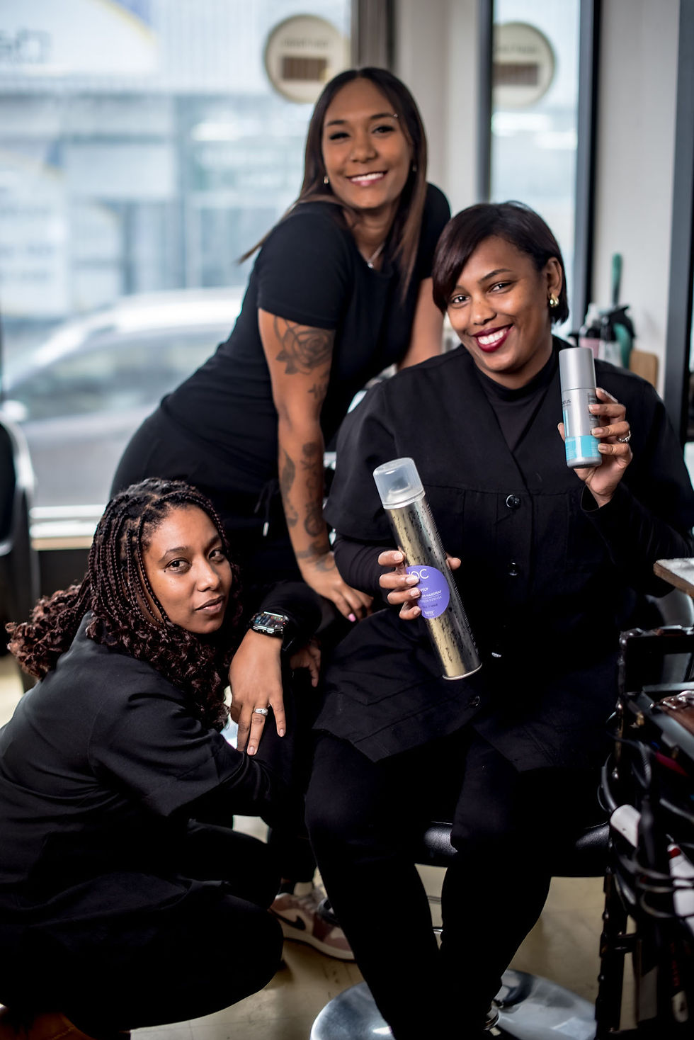 Three hair stylists wearing all-black