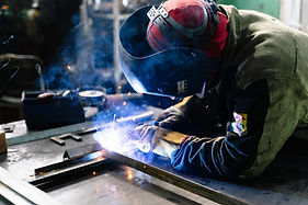 Welder welding a steel autonomous mobile robot riser frame