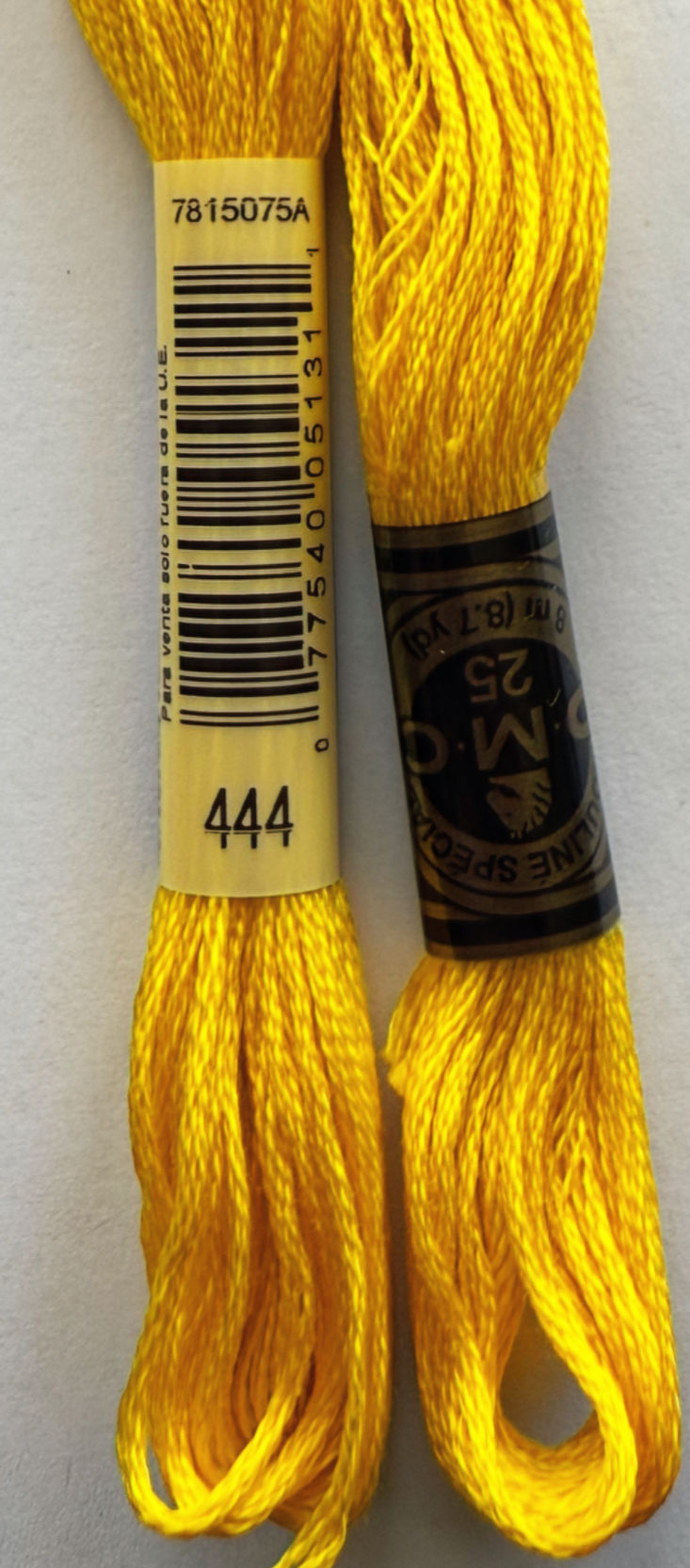 Two yellow DMC embroidery floss with barcode labels, labeled DMC 444 and 25.