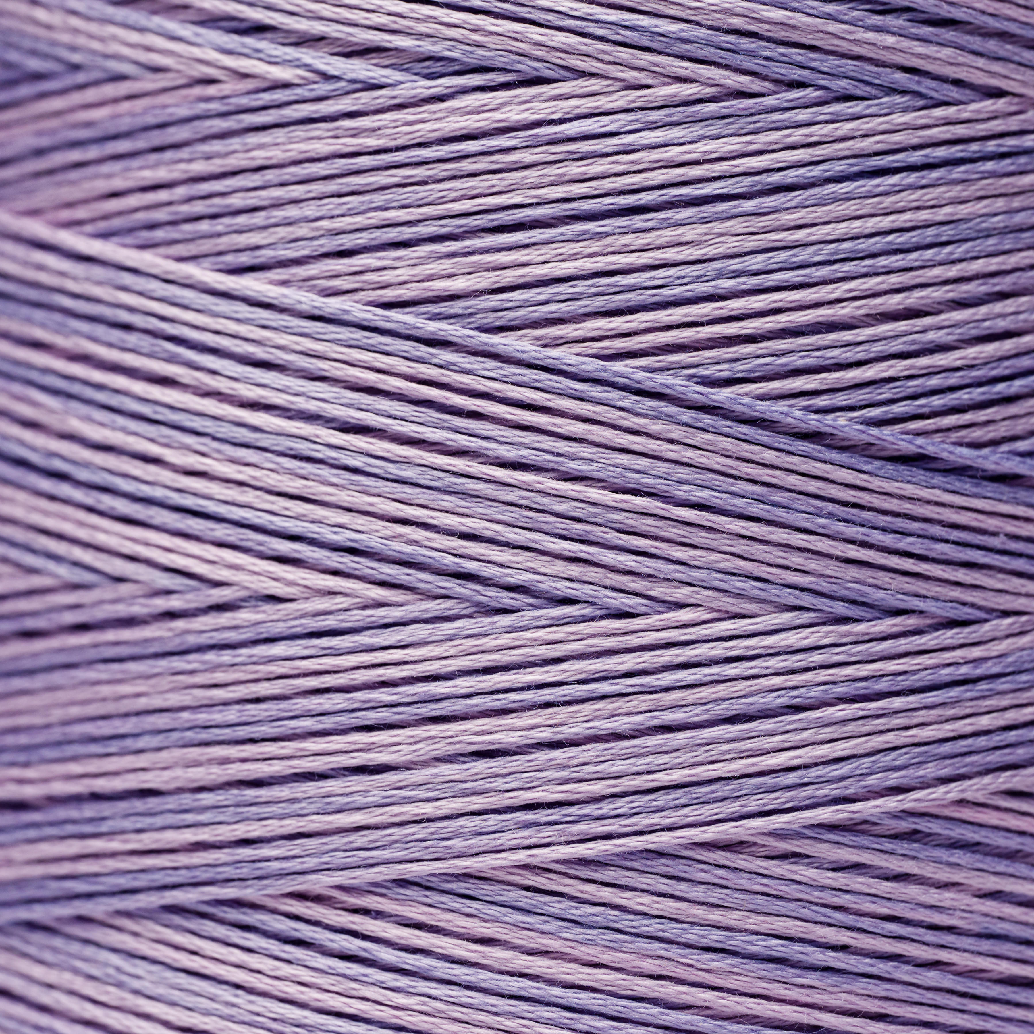Close-up of lavender thread, WDW 6550 – Bluecoat Blue, woven in a crisscross pattern.