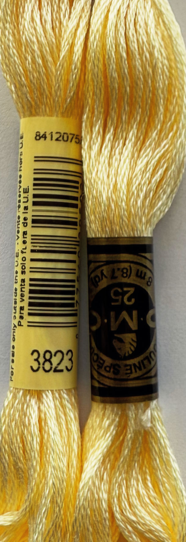 Two spools of DMC Floss Color 3823 Ultra Pale Yellow thread for craft projects.
