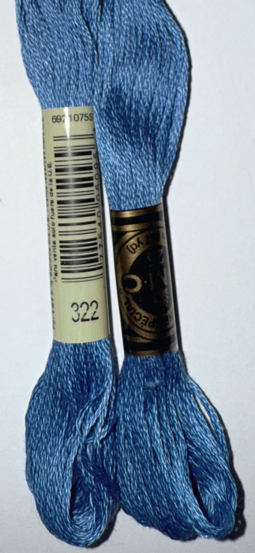 Two spools of blue DMC thread with visible text '322' detail.