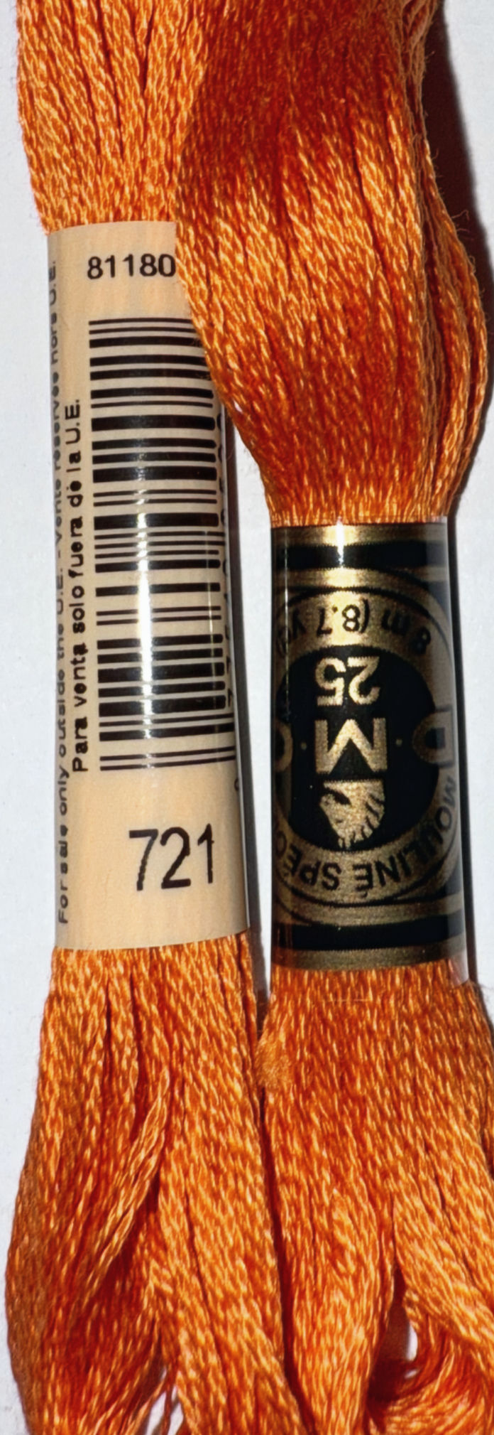 Orange embroidery floss with 721 and DMC brand labels, close-up view.