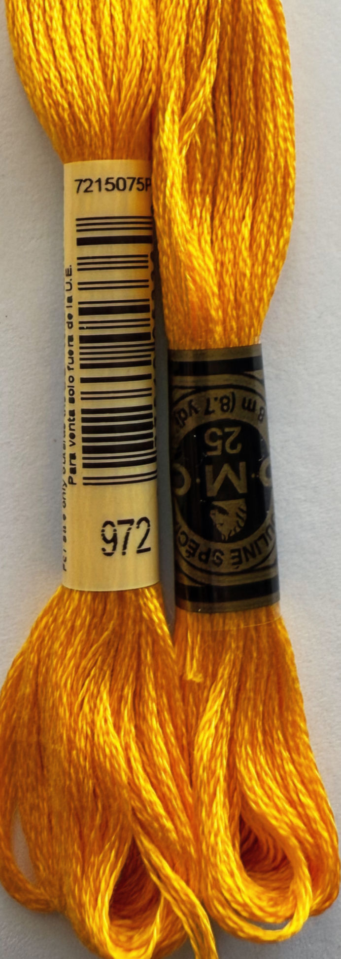 Two spools of DMC Floss with the number 972, yellow thread for crafts.