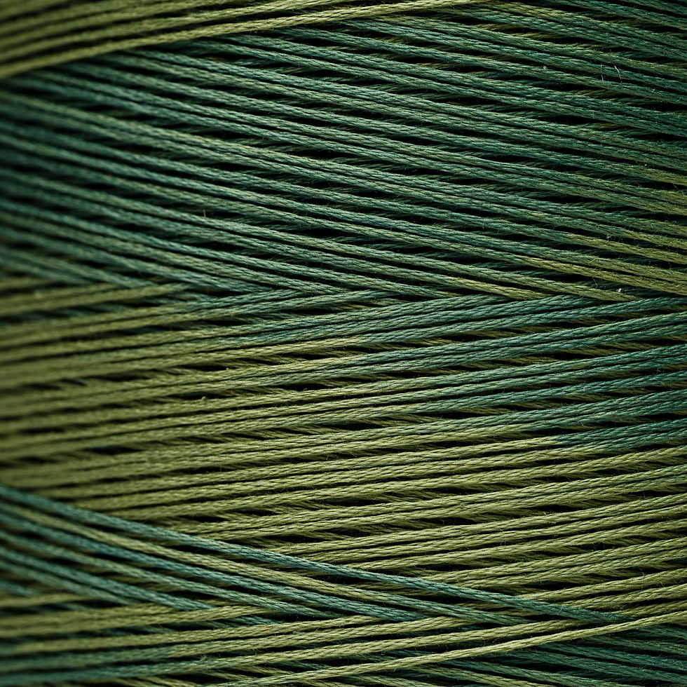 Close-up of green and olive thread spool, Bloomfield Craft for textile use.