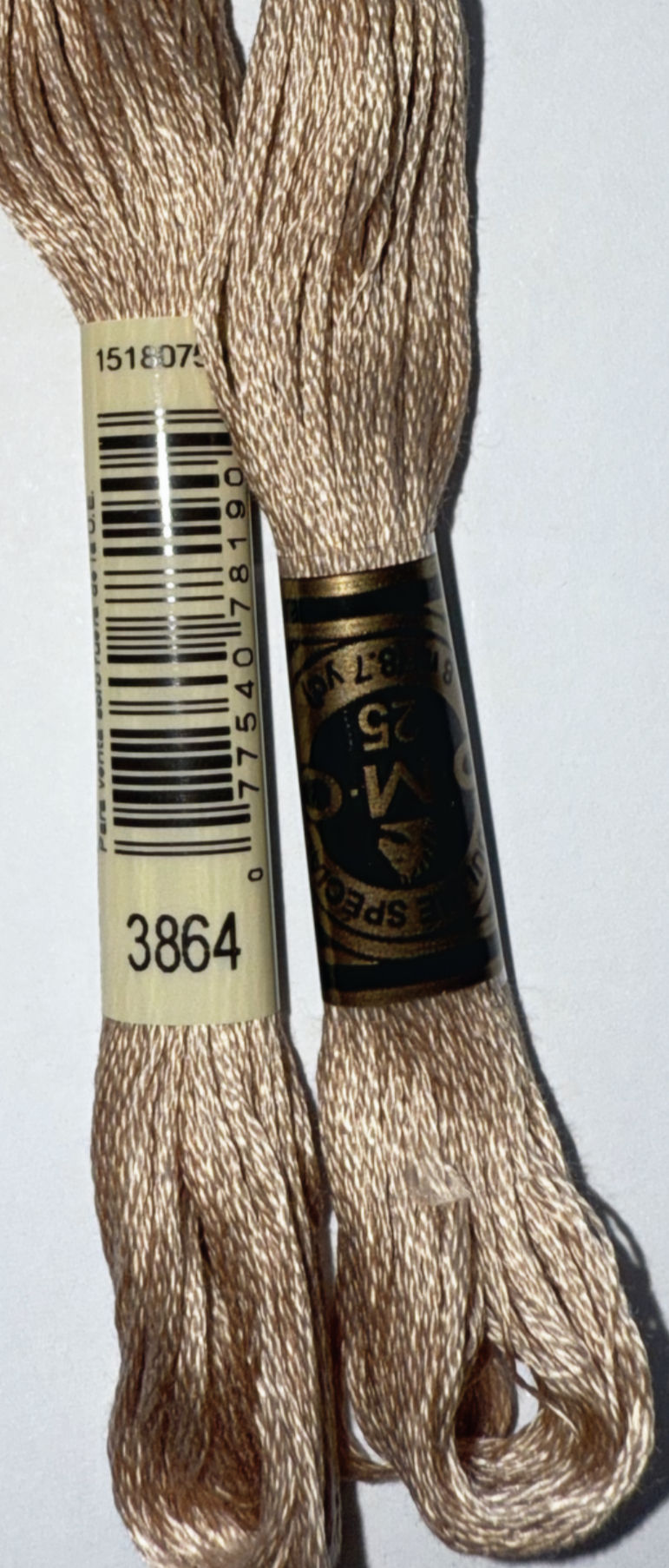 DMC embroidery floss with numbers 3864 and 25, a craft supply close-up.