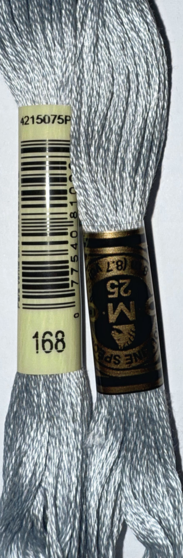 Two spools of DMC Floss Color 168 Very Light Pewter embroidery thread, close-up.