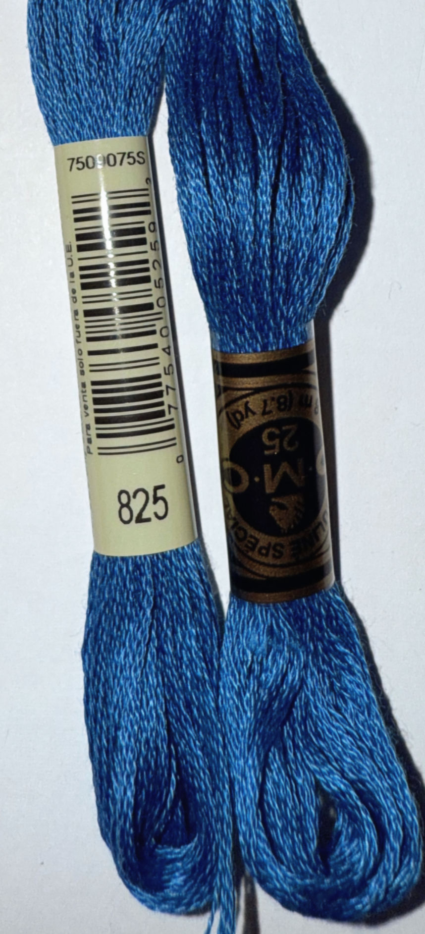 DMC Floss Color 825 and 25 blue thread spools on a white background. Bloomfield Craft