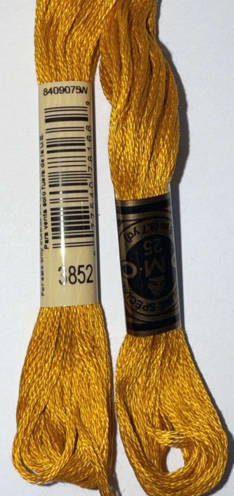 Two spools of yellow DMC embroidery floss with the numbers 3852 and details.