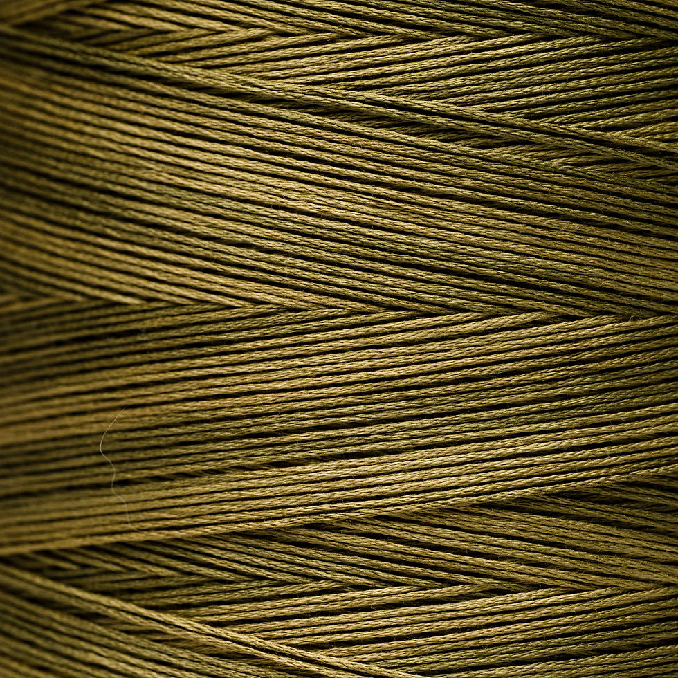 Close-up of golden-brown thread wound on a spool for sewing projects. Bloomfield Craft