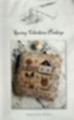 Front cover of “Spring Chickens Pinkeep” showing a stitched farm scene with chickens, house, and floral border.