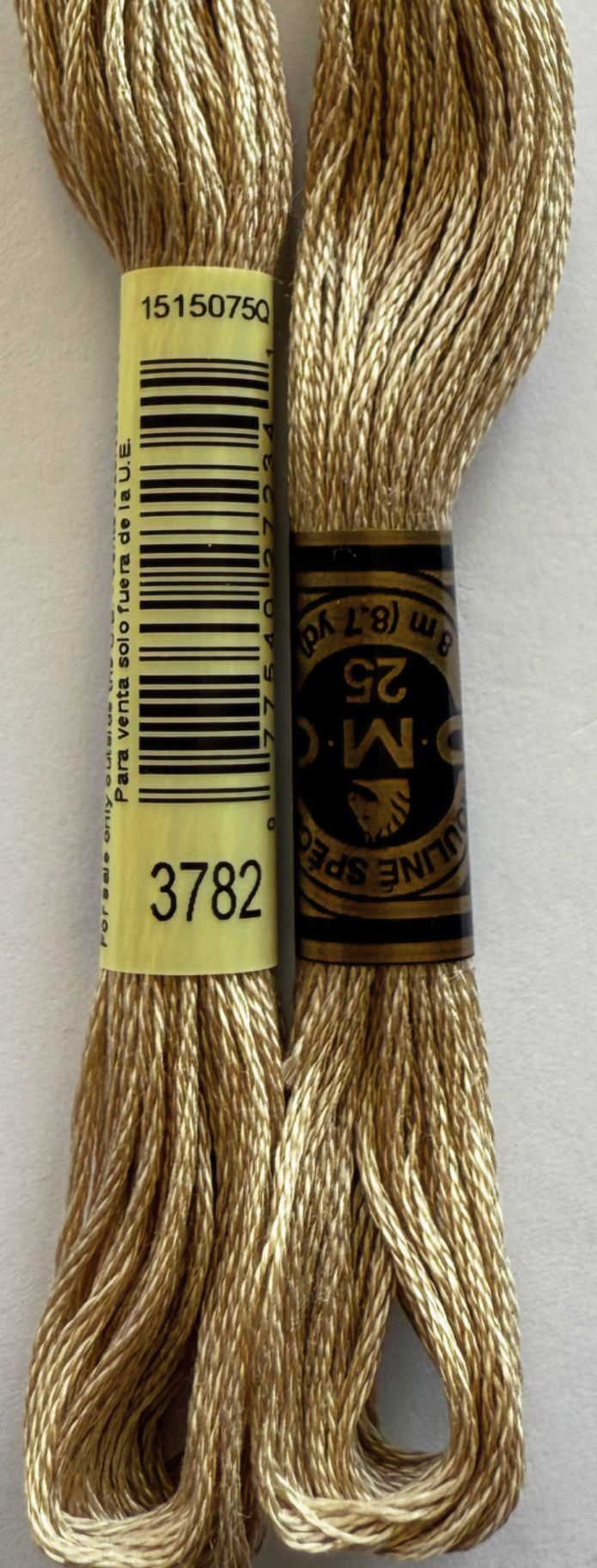 Two DMC embroidery floss skeins with tags reading 3782 and DMC 25.