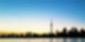 Silhouette of the Toronto skyline with CN Tower at dusk over water.