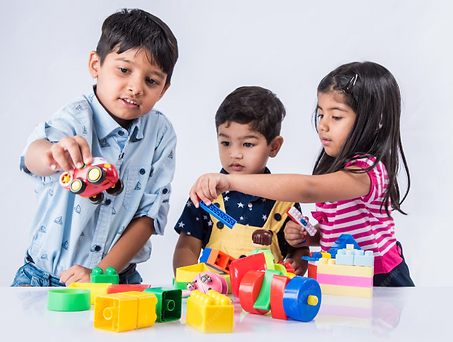 Three young children engaging in play-based interaction with toys, supporting communication, shared attention, and social engagement.”