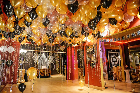 Gatsby theme decorations with balloons on ceiling.