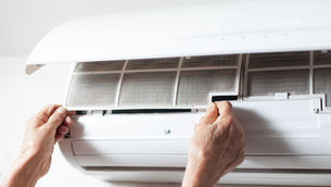 Image of a person reinstalling a min-split hvac unit filter