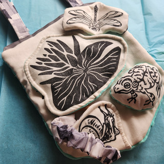 A banner shaped baby toy with peek-a-boo elements and noise inserts