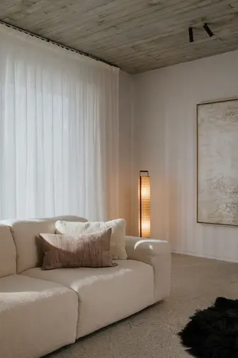 luxe setting van witte bank met wit linnen gordijnen