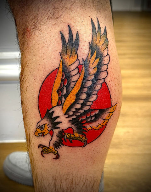 Traditional bald eagle with red sun in background tattoo done in Sheffield's most affordable and best tattoo studio by best artist in the city