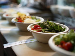 Custom green salads are lined-up next to each other for pick-up by customers. Image by Brian J. Tromp on Unsplash.