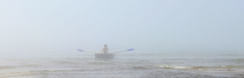 Person rows into a foggy sea in a tiny rowboat. Image by Geda Zyvatkauskaite on Unsplash.