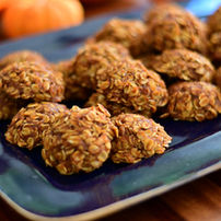 Mouthwatering homemade whole grain pumpkin cookies on a rustic, dark blue platter with bright orange pumpkins in the background. Image by MBR Imaging.