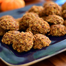 Mouthwatering homemade whole grain pumpkin cookies on a rustic, dark blue platter with bright orange pumpkins in the background. Image by MBR Imaging. 