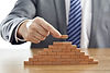 businessman-suit-putting-last-piece-pyramid-using-wooden-blocks.jpg