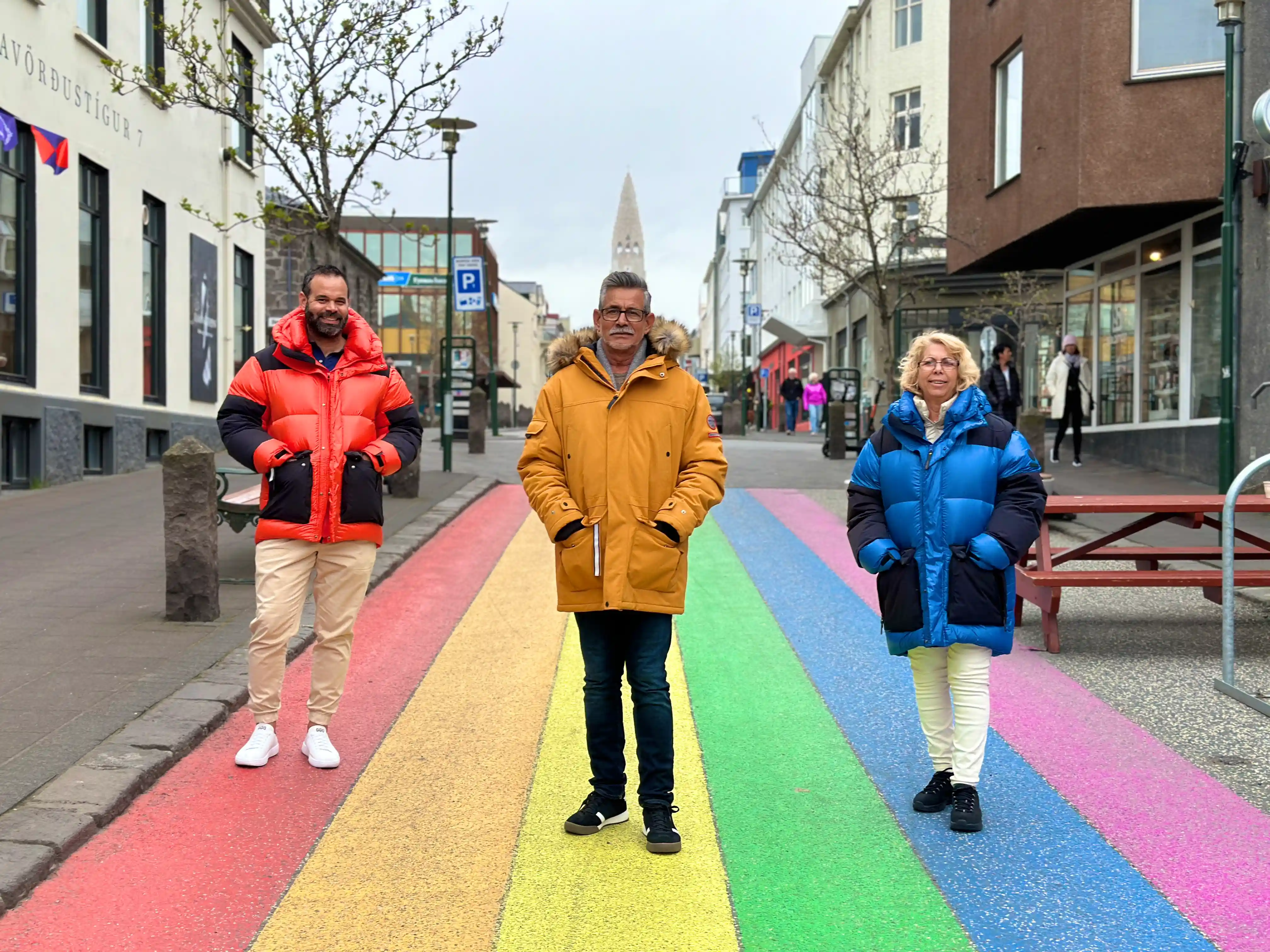 A family standing on the main street in Iceland showing the main chuch and rainbow street