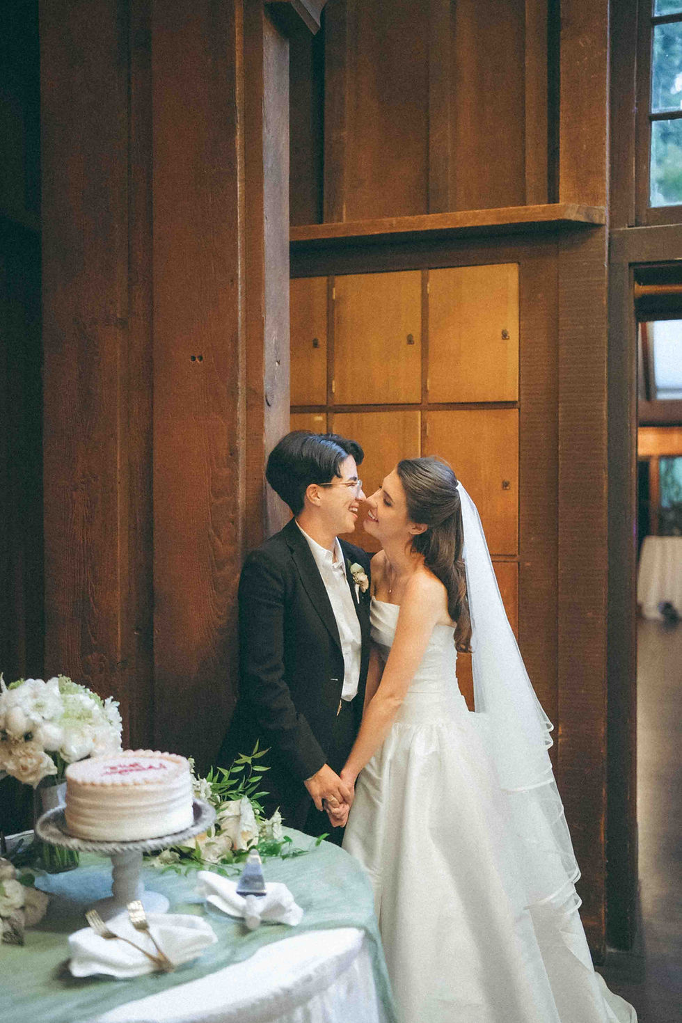 newlyweds kissing on their wedding during cake cutting, photo by wedding photographer - Kin Photography