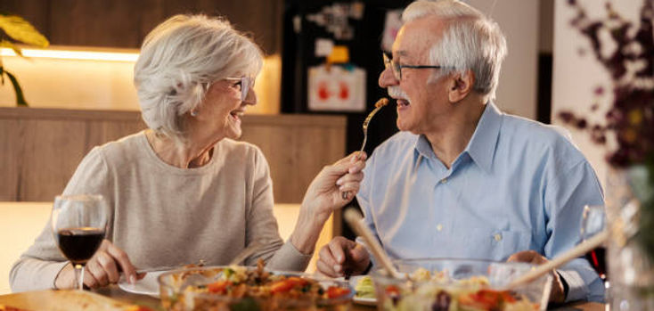 Happy retired couple sharing a meal, feeling secure with their insurance coverage