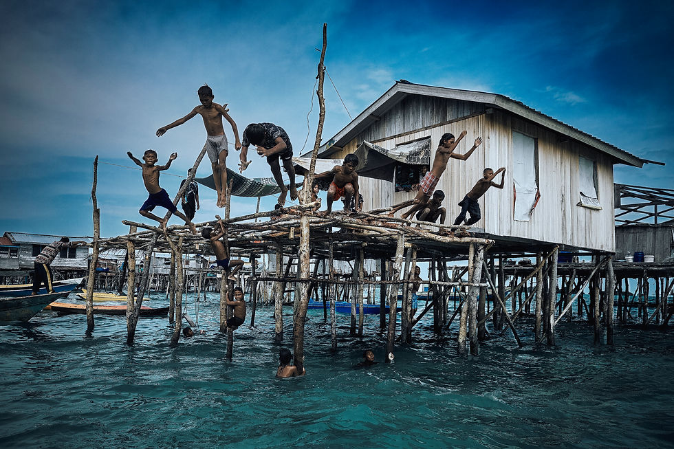 Grupo de niños Bajaul se lanza desde la plataforma; el mar funciona como parque y frontera porosa entre juego y oficio. Fotografía: John Cuesta 2025 / Archipiélago de Semporna, Sabah, Borneo (©) John Cuesta - Todos los derechos reservados