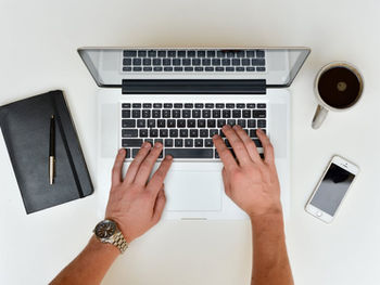 Mains qui écrivent sur un clavier d'un ordinateur portable