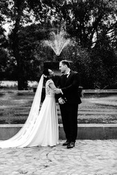 Photographie noir et blanc prise par Thomas Beauquesne, photographe de mariage en Seine-et-Marne, montrant Anna et Romain dans une pose complice dans le parc de l’Abbaye de Cercanceaux.