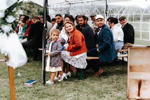 Sourires et larmes d’émotion des invités pendant la cérémonie laïque, mariage vintage à La Chapelle-Gauthier, style cinématographique et contrasté.