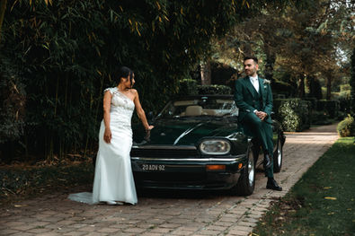 Photo de mariage prise par Thomas Beauquesne, montrant deux mariés posant pour leurs photos de couple, adossés à une Jaguar