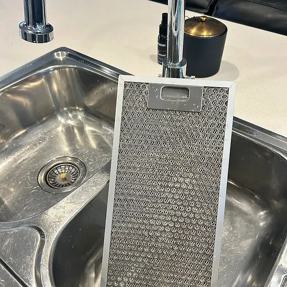 Degreased aluminum rangehood mesh filter and polished dual stainless steel sink extraction during a premium Hampton spring cleaning service by Whole Detail.