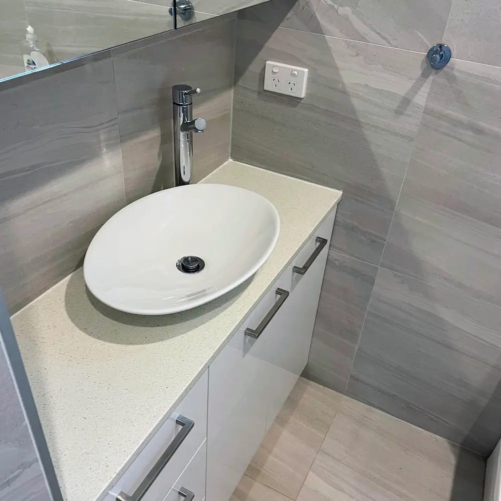 Stone vanity countertop, oval vessel basin, and polished chrome mixer tap detailed during 3 bed 3 bath spring clean. 