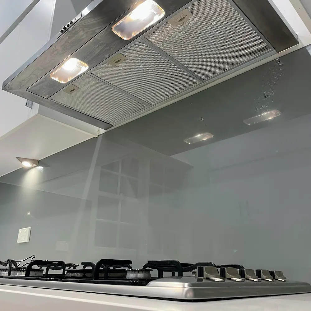 Illuminated rangehood mesh filters, gas cooktop, and polished glass splashback degreased during 4 bed 1 bath spring clean. 