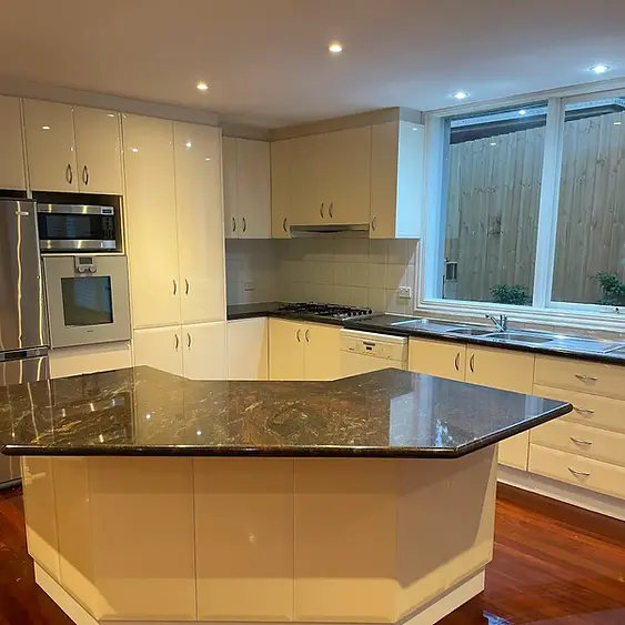 Polished granite island benchtop reflection and floor-to-ceiling gloss cabinetry maintenance inside a luxury Mentone residence by Whole Detail.