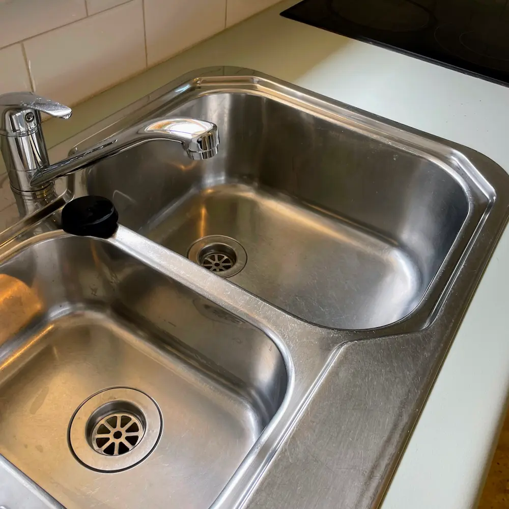 Dual-bowl stainless steel kitchen sink and mixer tap descaled and polished by Whole Detail. 