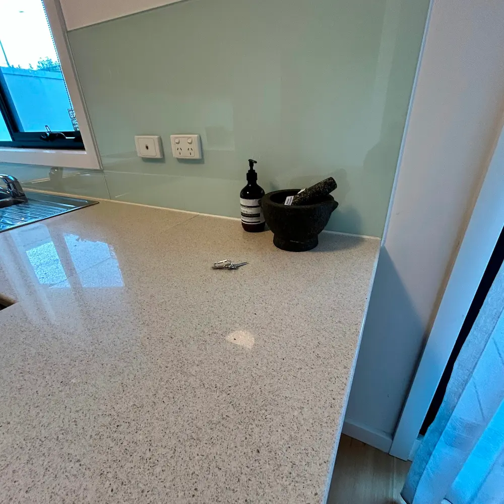 Engineered stone kitchen benchtop and splashback detailed during 3 bed 1 bath spring cleaning. 