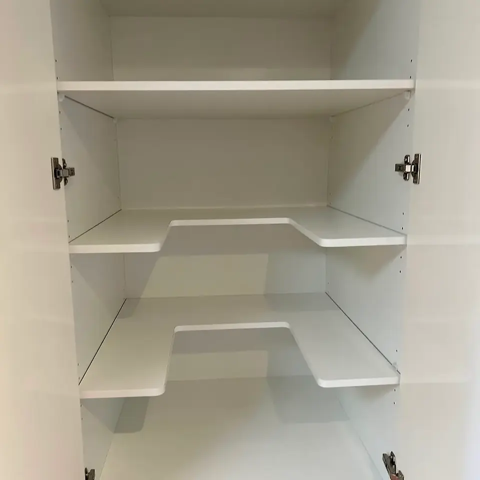 White walk-in pantry shelving interior wiped clean of food residues and dust.