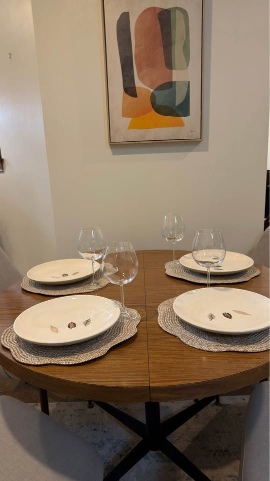 Thumbnail: Modern round wood dining table with black metal base