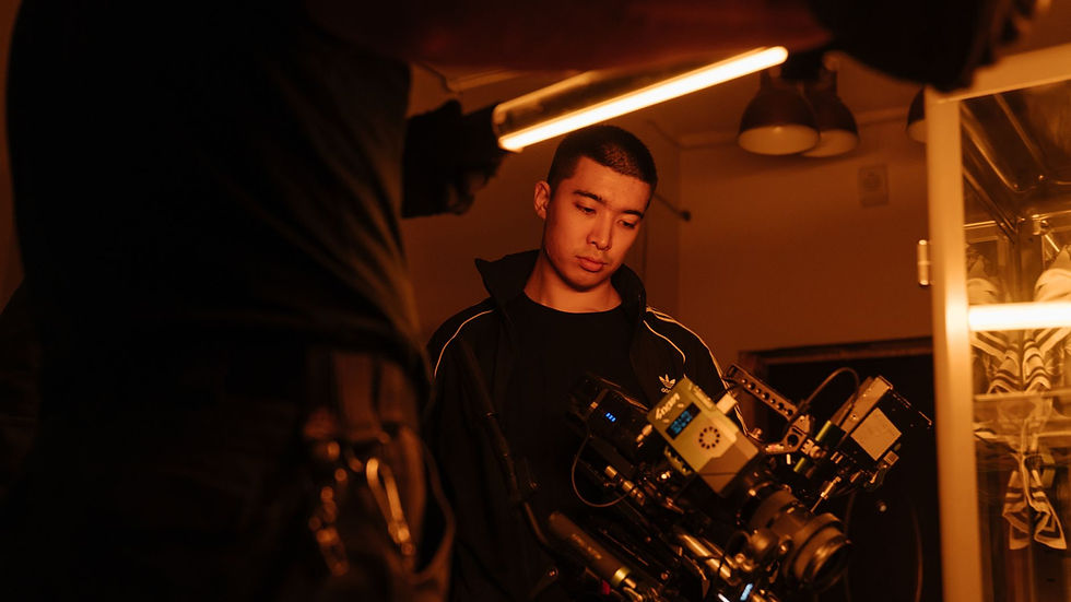 Film crew member adjusting camera setup under neon lighting, capturing creative filming process indoors.