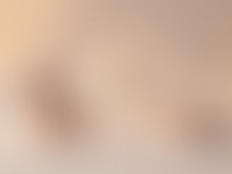 Two handcrafted figures sitting in meditation posture facing a softly glowing sphere with a pastel rainbow halo