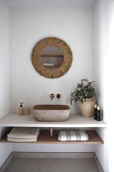Bathroom with stone tiles and warm, neutral tones – Nordic-Mediterranean fusion design.